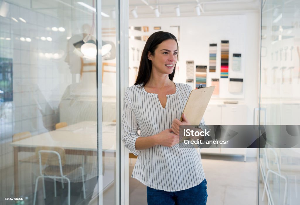 Thoughtful interior designer working at her office Portrait of a thoughtful interior designer thinking at her office and smiling - creative occupation concepts Home Interior Stock Photo