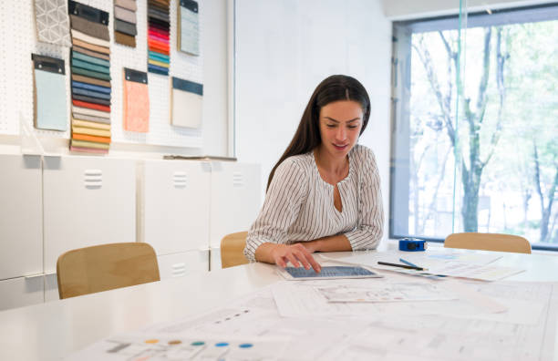 istock Interior designer looking at pictures on her tablet at the office 1346781656