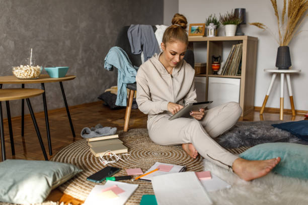 istock Full length shot of female student checking her schedule on digital tablet while studying 1346781828