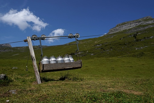 Device for transport of milk canisters with pulley. Agricultural technology on pastures in Alp mountains of high altitude in Switzerland.