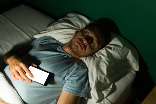istock Handsome man addicted to his phone 1346783402