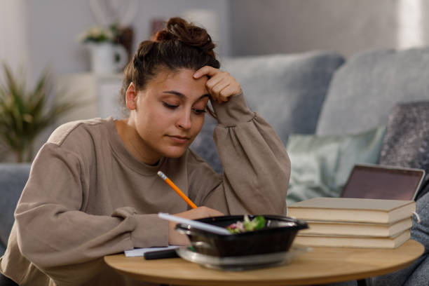 istock Young woman writing homework in her notebook after studying 1346783463