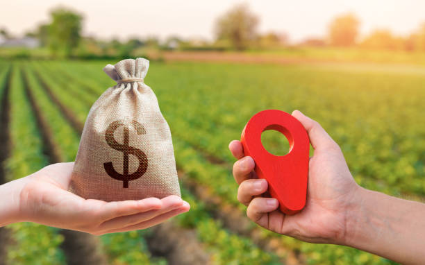 Hands with location pin and money bag. Buying and selling land. Land market. Estimation cost of plots. Legal regulation of property. Agriculture agribusiness. Transport and construction industry. manos con pin de ubicación y bolsa de dinero. compra y venta de terrenos. mercado de tierras. estimación del coste de las parcelas. regulación legal de la propiedad. agroindustria agroindustrial. industria del transporte y la construcción.