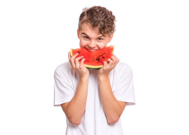istock Teen boy eating watermelon 1346786225
