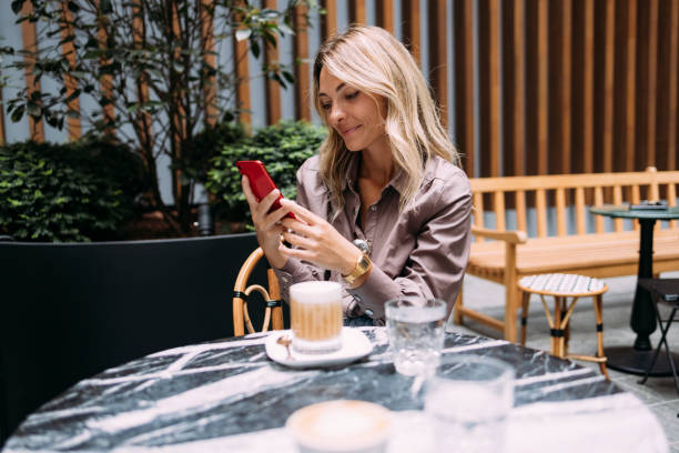 istock Happy Businesswoman Using Mobile Phone in a Cafe 1346787127