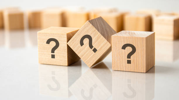 istock three question marks written on wooden cubes, lying on the gray table, concept 1346788692