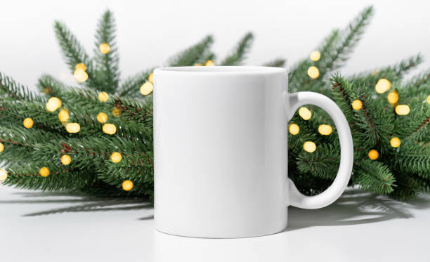 istock Christmas mockup one white empty tea mug on a white table and branches of a Christmas tree wreath. 1346789402