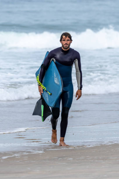 Bodyboarder walking Bodyboarder walking in S. Jacinto beach near Aveiro - Portugal. body board stock pictures, royalty-free photos & images