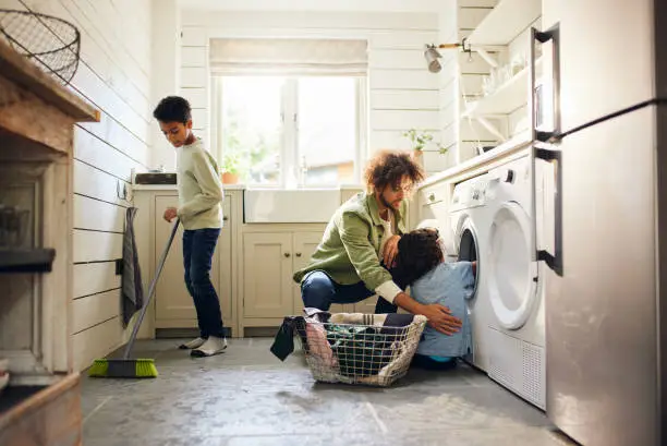 Photo of Two boys helping father with household chores