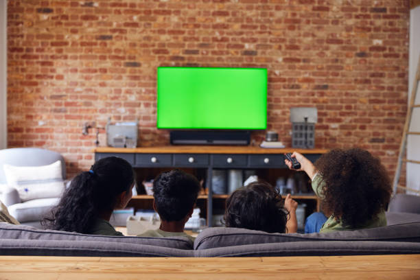 istock Family watching TV at home on sofa. 1346794893