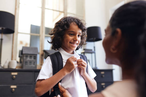 istock Boy smiling at mother as he gets ready for school 1346794926
