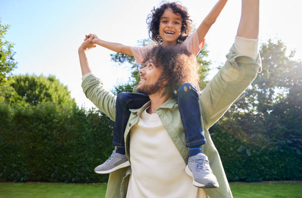 istock Father with son on shoulders and arm outstretched 1346794957