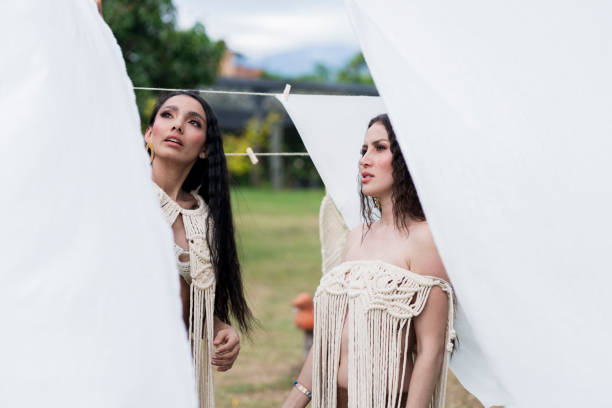istock Two Latina friends model self-made clothes in macrame while taking a selfie 1346796083