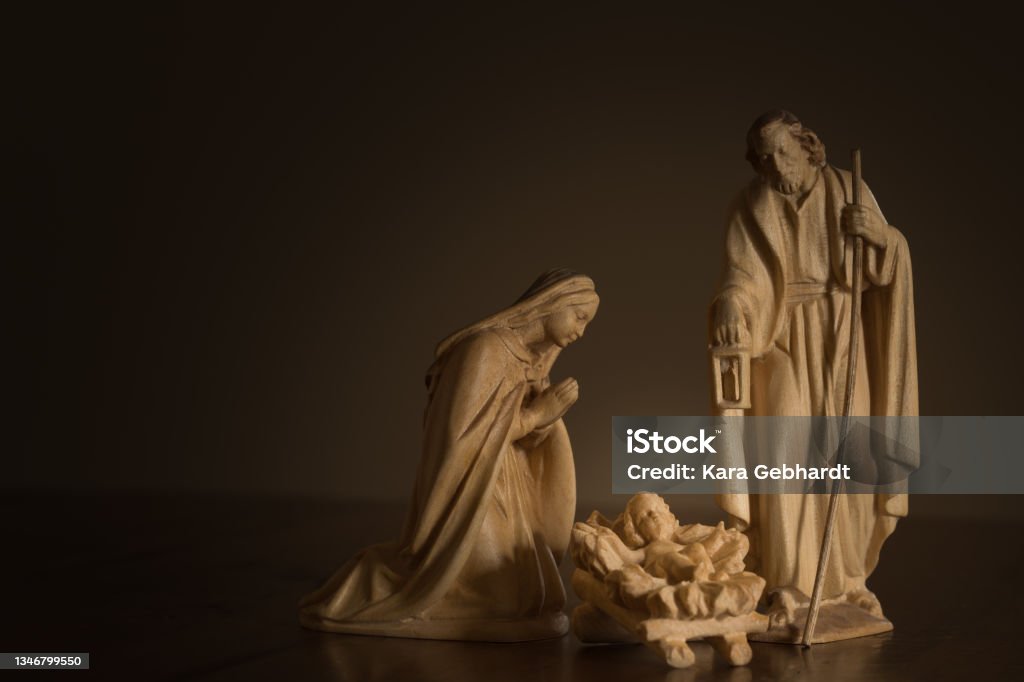 Simple wood nativity Wood nativity figures of Mary, Joseph and baby Jesus with a dark background and copy space Nativity Scene Stock Photo