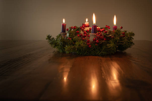 istock Advent wreath with four candles lit on a dark wood table 1346799580