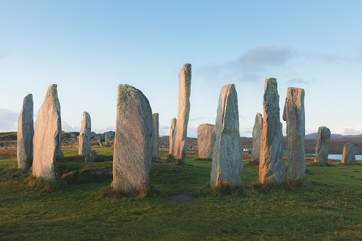 The historic site of Callanish Standing Stones, a Neolithic stone circle on the Isle of Lewis in the Outer Hebrides of Scotland at sunset or sunrise.