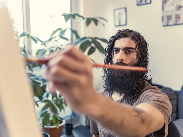 istock Young Caucasian man painting in studio 1346802315