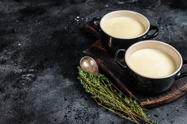 istock Potato cream soup in bowls on kitchen table. Black background. Top view. Copy space 1346803748