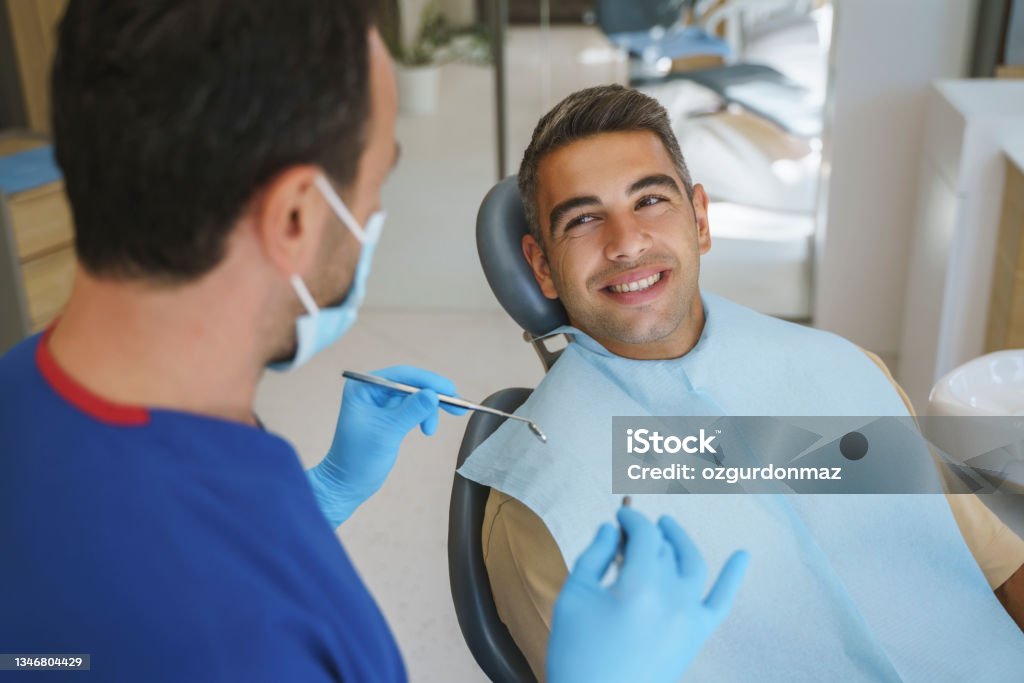 Young man patient having dental treatment at dentist's office Dentist Stock Photo