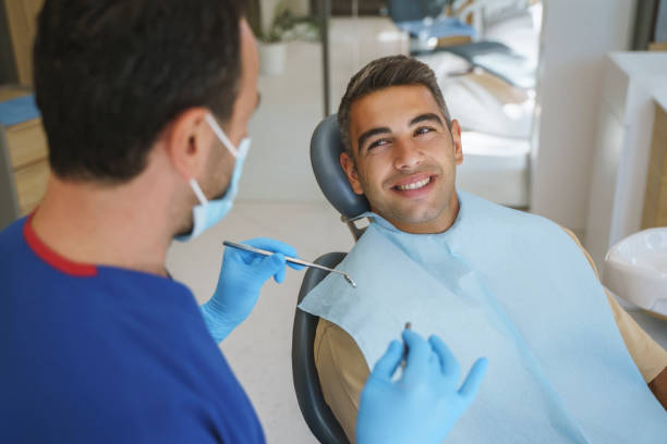 Young man patient having dental treatment at dentist's office stock photo