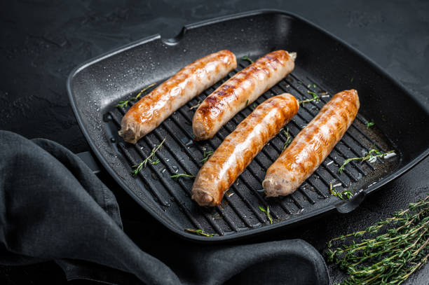 istock German grilled Bratwurst sausages in a grill pan. Black background. Top view 1346806685