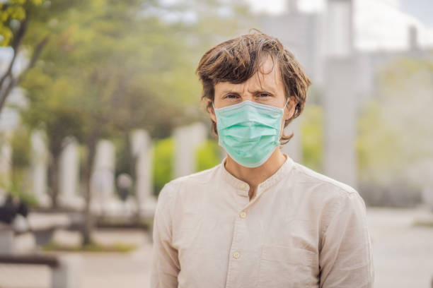 hommes portant un masque hygiénique facial pour la sécurité à l’extérieur. des gens masqués à cause de la poussière fine. problèmes rencontrés dans les grandes villes du monde entier. pollution de l’air,concept de sensibilisation à l’envir - sales manager photos et images de collection