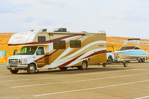 Travel trailer towing a boat. Lake Powell beach, parking lot.  Lake Powell, Utah, USA - September 29, 2021