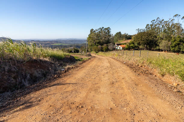 istock Farm house and fields with dirty road 1346815032