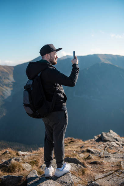 istock Tourist takes on smartphone mountain scenery 1346820830