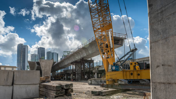 Heavy machinery and workers working on the construction of a new viaduct along the north of downtown Miami, where new luxury housing complexes are being developed.