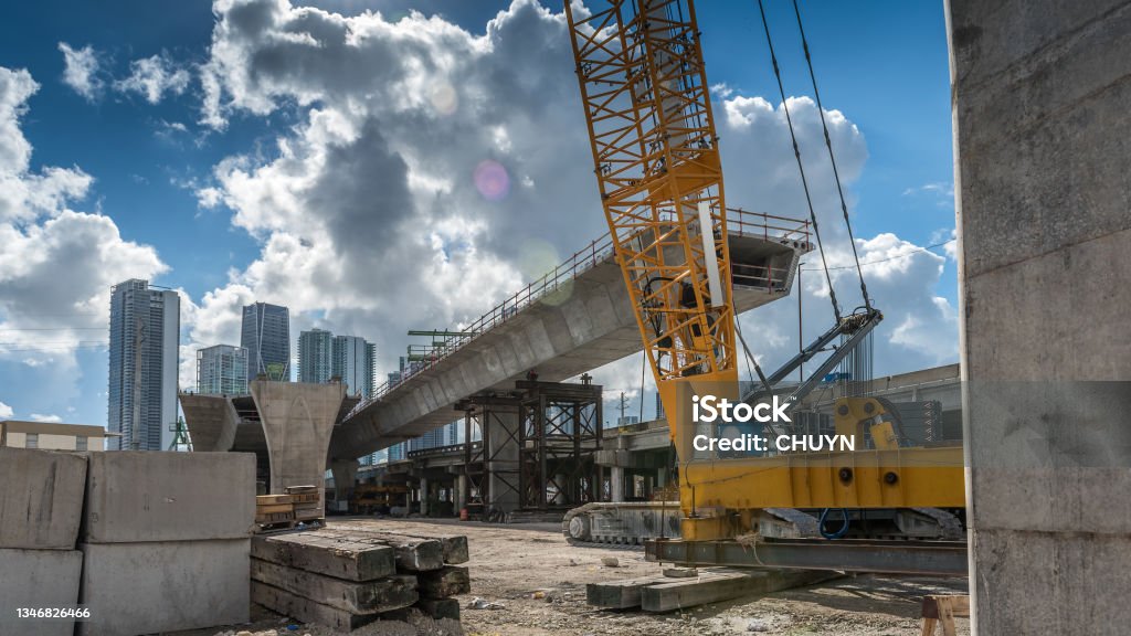Miami new overpass Heavy machinery and workers working on the construction of a new viaduct along the north of downtown Miami, where new luxury housing complexes are being developed. Construction Site Stock Photo