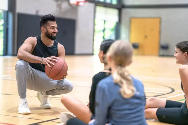 Photo of Teacher Instructing Students About Basketball
