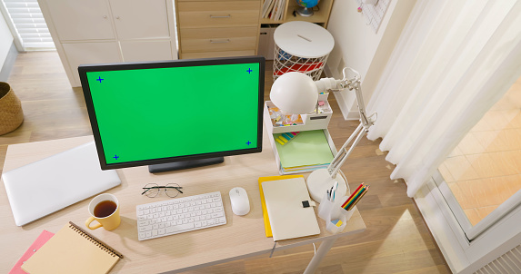 top view of home office interior with green screen monitor computer on desk