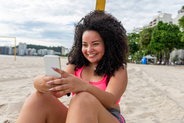 istock Young chubby sportswoman enjoys time at the beach after workout 1346844736