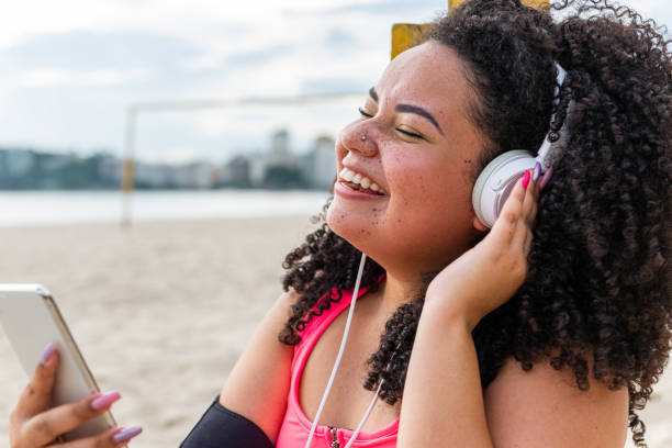 istock Young chubby sportswoman enjoys time at the beach after workout 1346844778