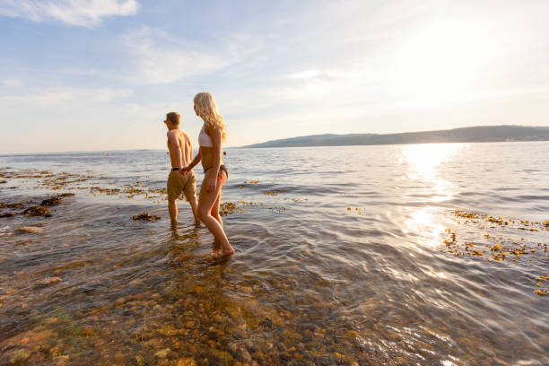 istock Young Couple Holding Hands Wading In Sea 1346851740