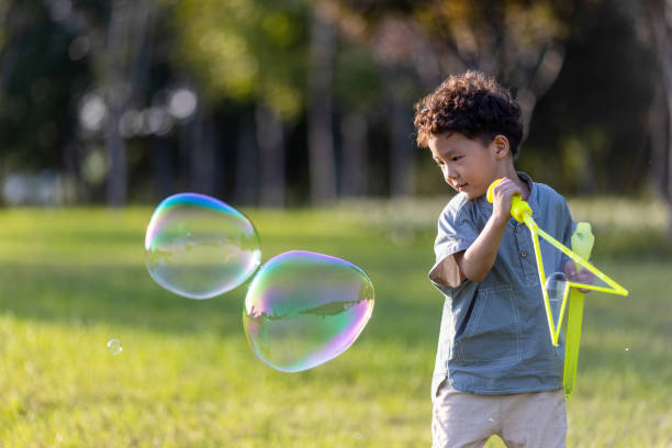 istock A little boy playing with soap bubbles in the park 1346852173