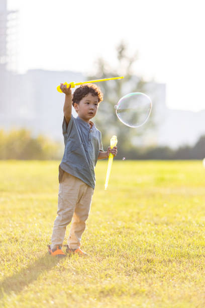 istock A little boy playing with soap bubbles in the park 1346852174