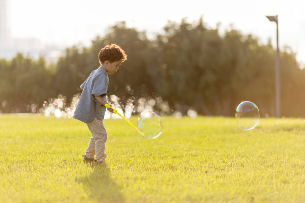 istock A little boy playing with soap bubbles in the park 1346852732