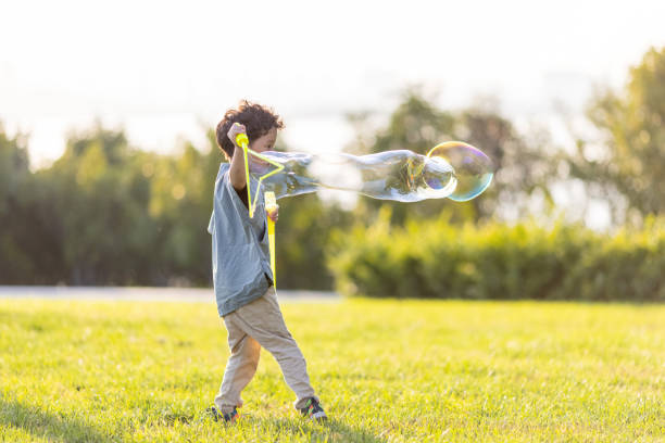 istock A little boy playing with soap bubbles in the park 1346852820