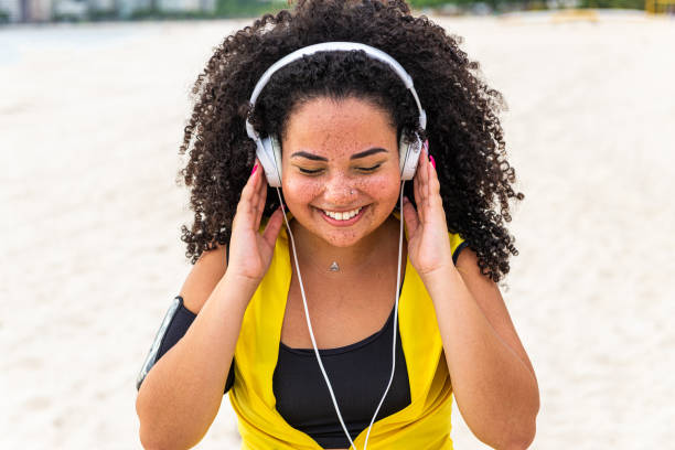 istock Young chubby sportswoman enjoys time at the beach after workout 1346853751