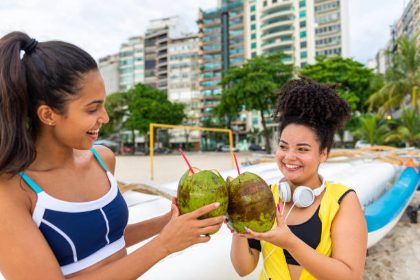 istock Best friends enjoy the beach while drinking coconut water 1346853940