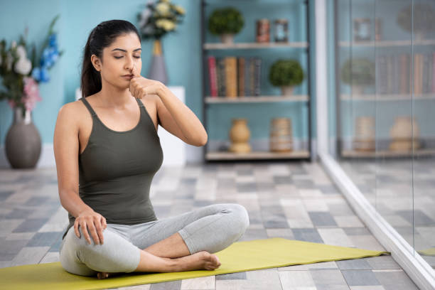 Beautiful attractive young woman doing yoga exercising at home, Health concept, Fitness concept, stock photo India, Adult, Adults Only, Alternative Lifestyle, Balance sukhasana stock pictures, royalty-free photos & images