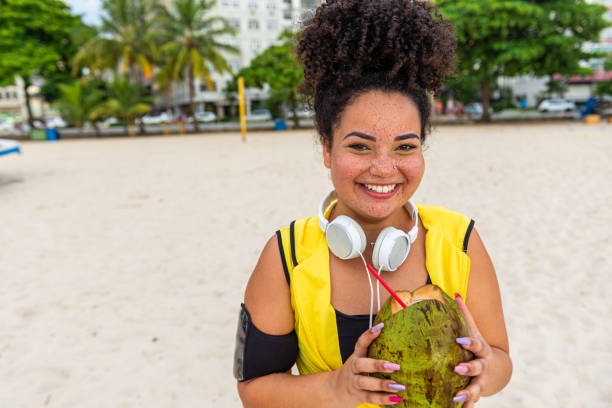 istock Young athletic woman with a coconut at the beach 1346856508