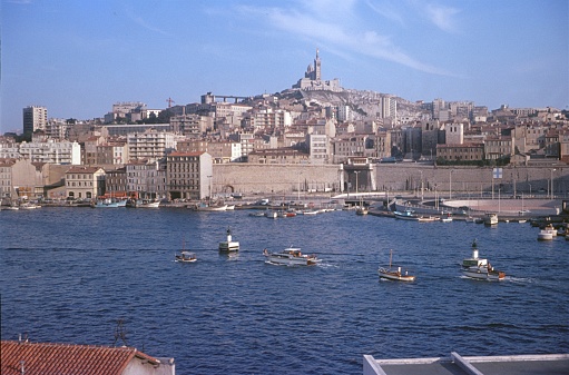 Marseille, Provence-Alpes-Côte d'Azur, France, 1969. The port of Marseille. In the background, Notre-Dame de la Garde.