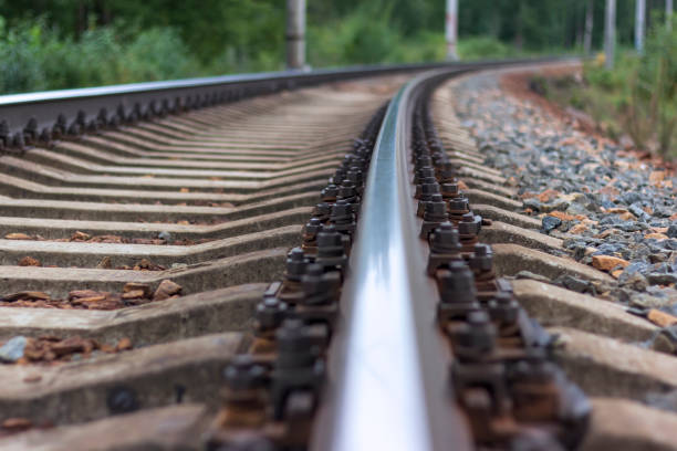Railway rails and sleepers close-up. Railway rails and sleepers close-up. A railway that goes around a bend in the distance. rail transportation stock pictures, royalty-free photos & images