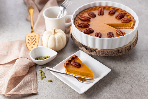 Tasty pumpkin pie, tart made for Thanksgiving day on gray background