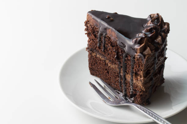 schokoladenkuchenstück auf weißem grund mit kuchenzweig und platz für text - chocolate cake stock-fotos und bilder