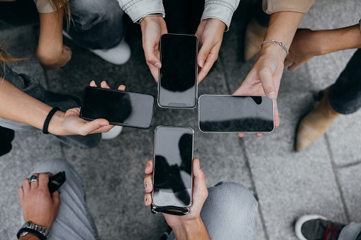 Close up of people using mobile smart phones - Detail of friends sharing photos on social media network with smartphone - Technology concept