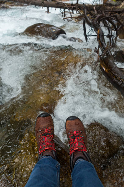 istock Women's feet in trekking boots 1346873649